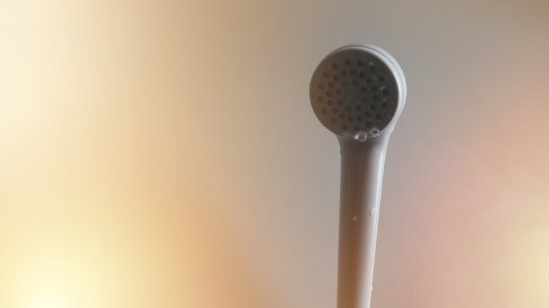 靠近塑料头淋浴和水滴在浴室墙壁的背景图片下载