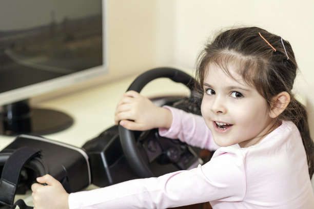 女孩与虚拟现实眼镜VR头和赛车轮图片下载