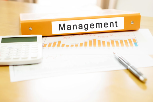 办公室办公桌上的橙色活页夹和计算器和钢笔图片下载