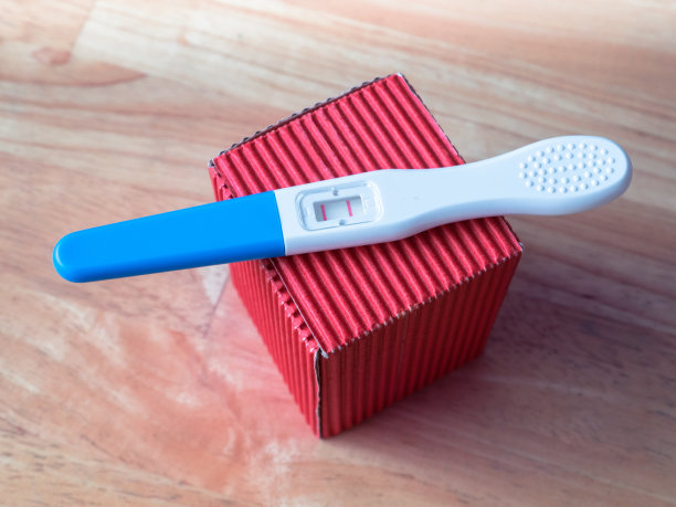 红色礼品盒上的妊娠检测呈阳性图片下载