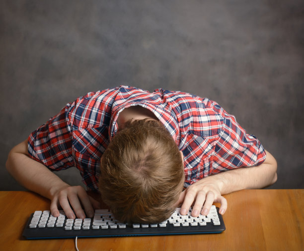 男人睡在键盘上。图片下载