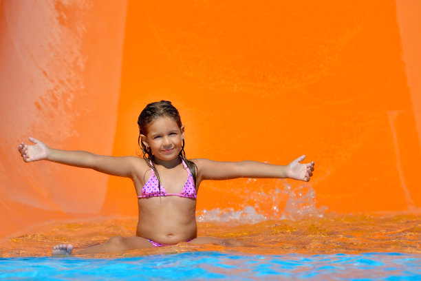 可爱的蹒跚学步的小女孩在水上公园享受她的暑假图片下载