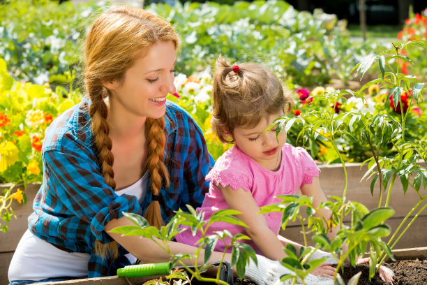 年轻漂亮的女人和她的女儿在花园里图片下载