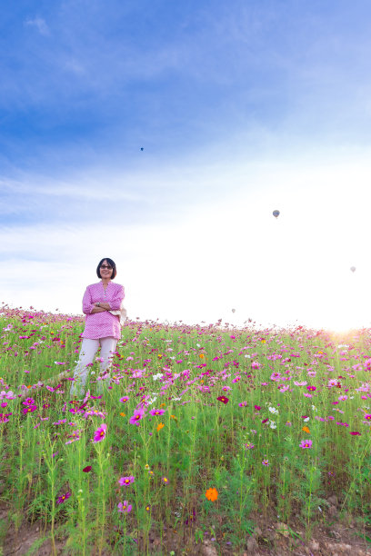 站在宇宙花丛中的女人图片下载
