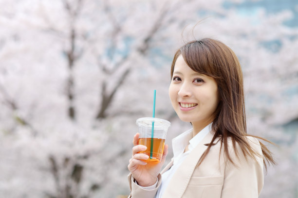 在樱桃树前喝茶的女商人图片下载
