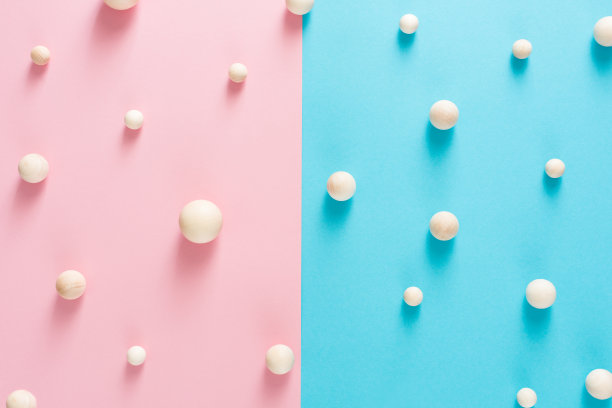 木制的工艺球在蓝色和粉红色的纸上做成两半的图案图片下载