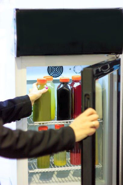 从冰箱里拿冷果汁的女人图片下载