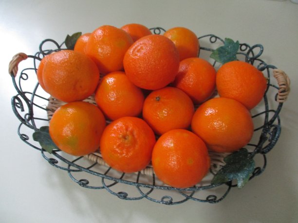 绿铁丝篮子里五颜六色的小柑橘图片下载