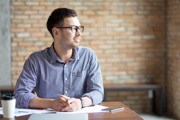 沉思的年轻人在咖啡馆里做项目图片下载
