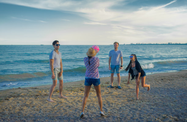 日落时分，朋友们在狂野的海滩上打排球图片下载