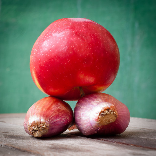 木桌上放大葱、洋葱和苹果图片下载