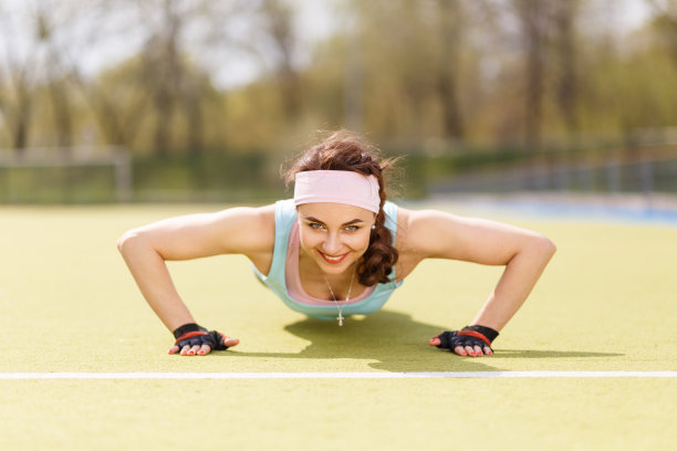 年轻迷人的女人在做俯卧撑或核心健身操图片下载