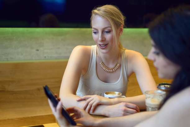 两个年轻女人在看数码平板电脑图片下载