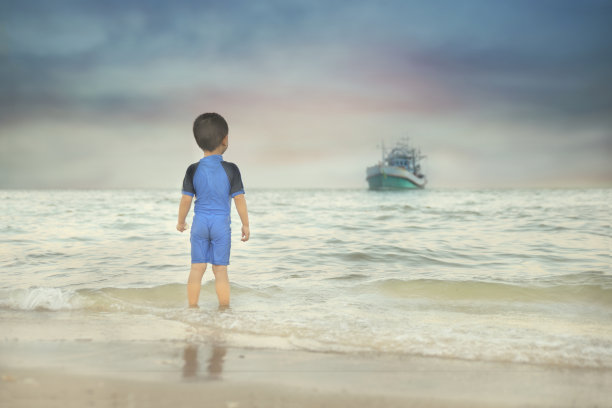 男孩盯着靠近的船图片下载