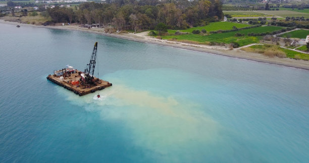 驳船用勺子从海底捞起沙子。无人机的景观照片。地中海。塞浦路斯图片下载
