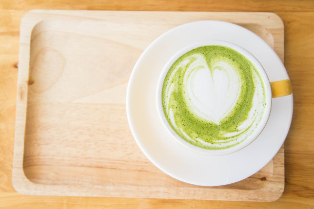 咖啡店木桌上的绿茶牛奶拿铁杯图片下载