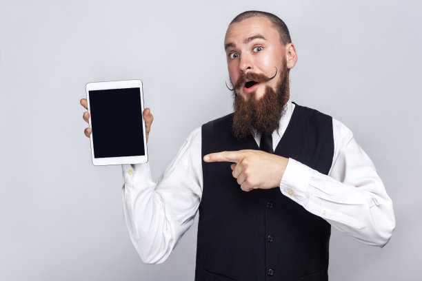 英俊的商人展示平板电脑屏幕和惊讶。图片下载