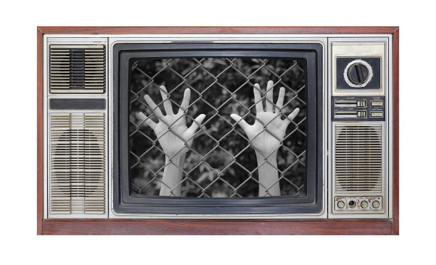 复古电视上的白色背景与形象的手触摸金属栅栏的屏幕。图片下载