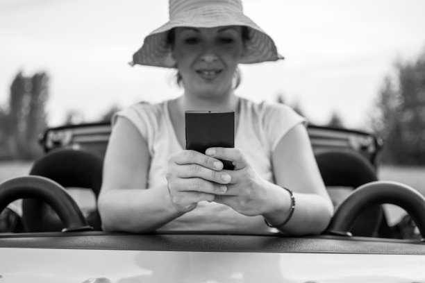 年轻迷人的女孩在车里使用手机图片下载