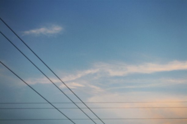 多云蓝天上的交叉电缆图片下载