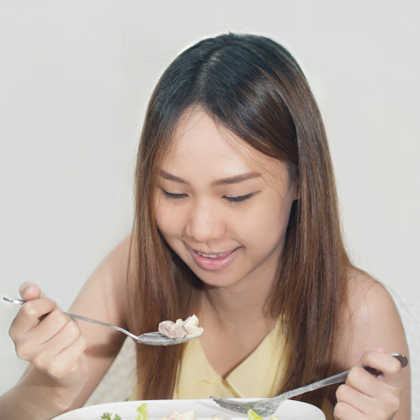 美丽的亚洲女人在家吃沙拉图片下载