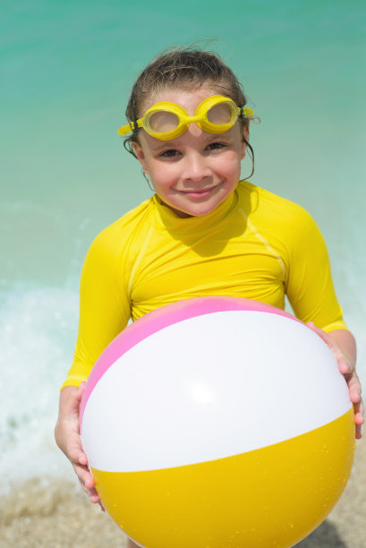 小女孩微笑着玩五颜六色的沙滩球图片下载