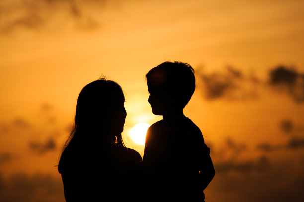 日落时分，幸福慈爱的母亲和年幼的儿子图片下载