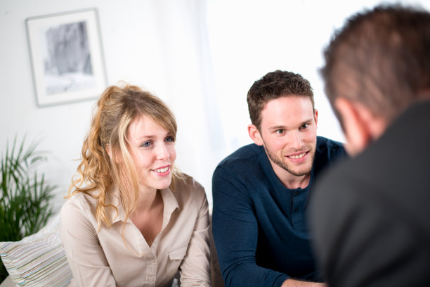 一对快乐的年轻夫妇和一个顾问销售员图片下载