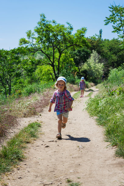 3岁和4岁的小妹妹们背着背包去徒步旅行。图片下载
