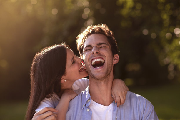 年轻女子咬她男朋友的耳朵图片下载