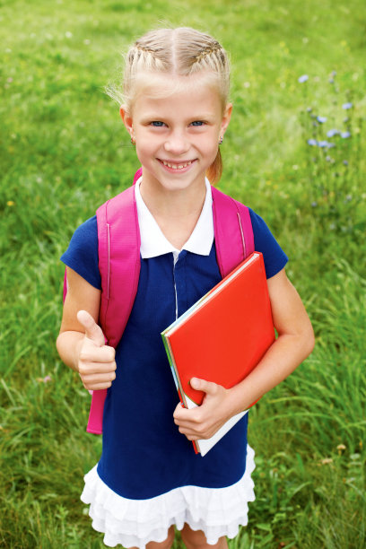 一个微笑的穿着蓝色校服的女学生的肖像。图片下载