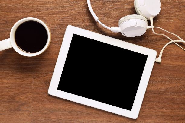 俯视图的平板电脑，耳机和一杯咖啡在木桌上图片下载