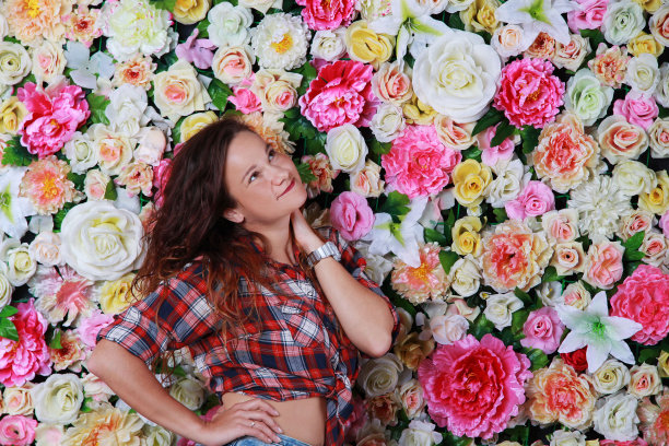 年轻浪漫的黑发女孩靠近花墙图片下载