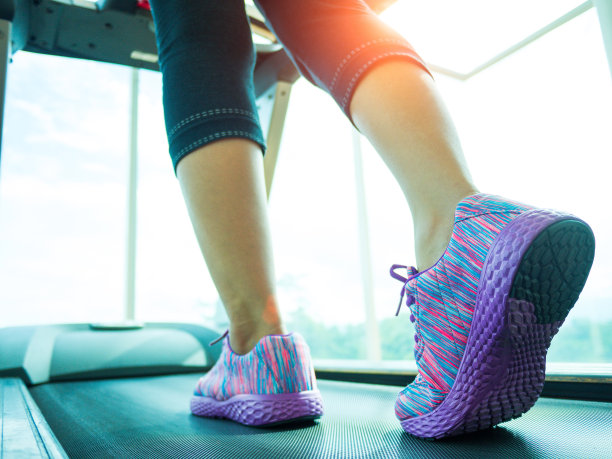 女人在健身房里的跑步机上踏步和奔跑素材图片