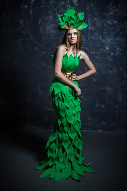 美丽的女孩模特摆姿势，长长的绿色连衣裙，时尚摄影工作室图片下载