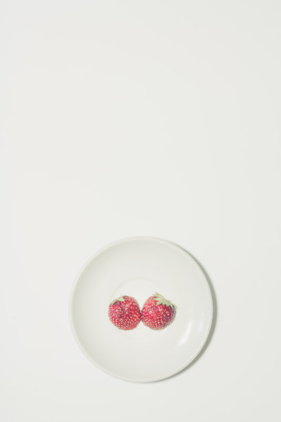 最小的草莓片背景。水果放在白色的盘子里。垂直设计的传单，横幅，封面或传单图片下载