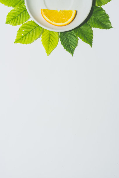 最小橙色切片背景。水果放在白色盘子里，周围是树叶。哑光色。垂直设计的传单，横幅，封面或传单图片下载