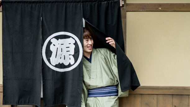 年轻人正穿过日本老店的门帘图片下载