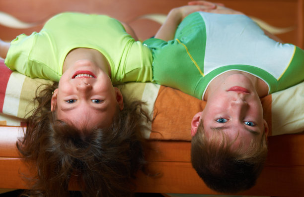 两个微笑的孩子躺在床上图片下载