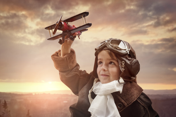 男孩在玩木制玩具飞机图片下载