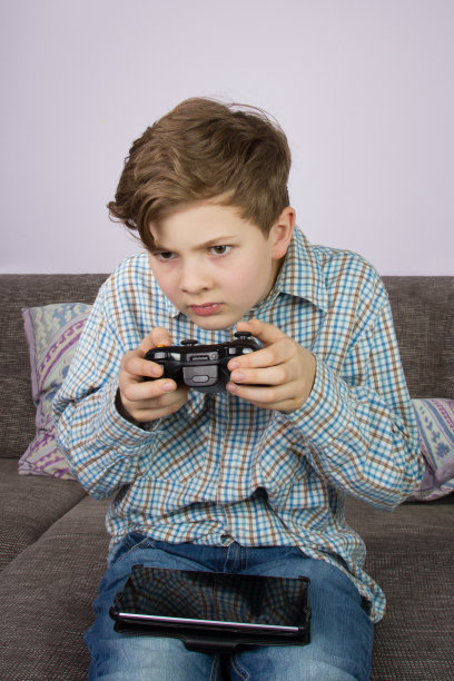 小男孩在平板电脑，游戏机和笔记本电脑上玩图片下载