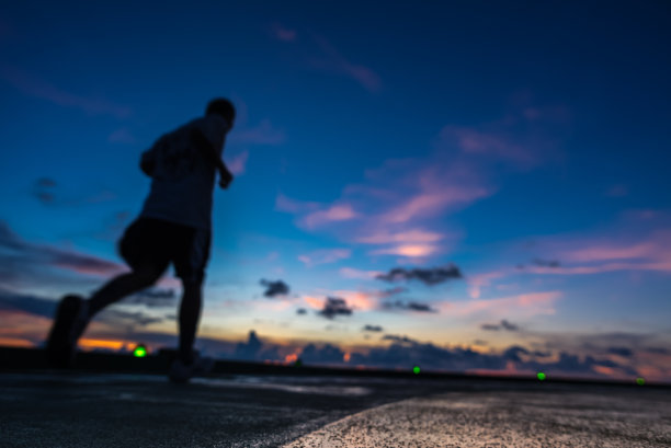 日落时分，人们在石油钻井平台的直升机停机坪上奔跑图片下载