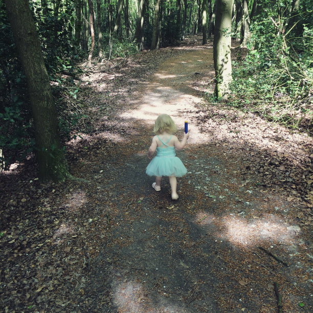 蹒跚学步的孩子穿过树林图片下载