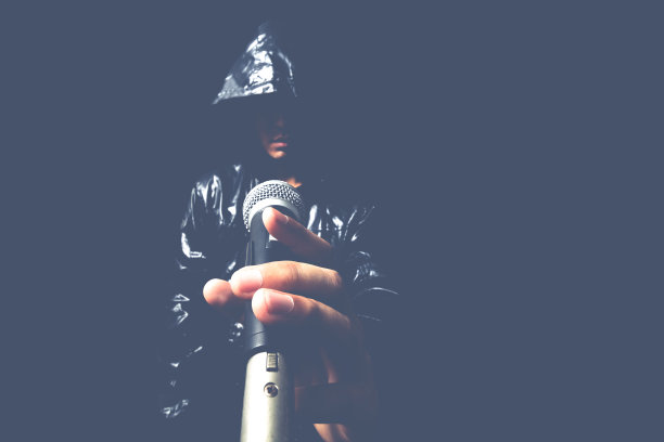 手的亚洲英俊歌手在动态麦克风图片下载