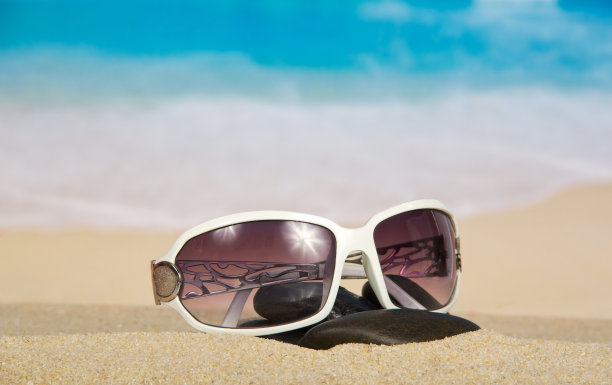 太阳镜和沙子上的鹅卵石图片下载