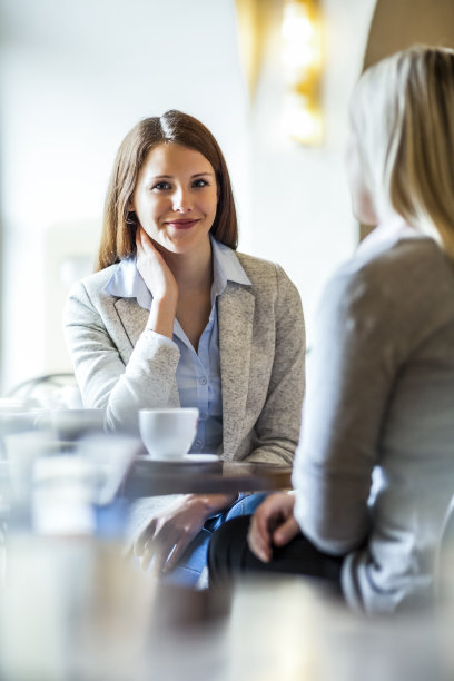 快乐的年轻女商人与女同事在咖啡店图片下载
