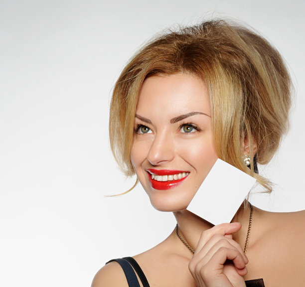 年轻漂亮的女人拿着一张卡片图片下载