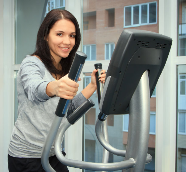 年轻女子在椭圆机上做运动图片下载