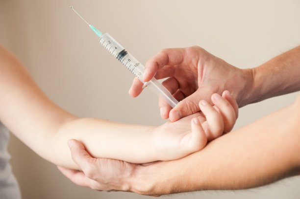 男性用注射器握住儿童的手进行注射图片下载