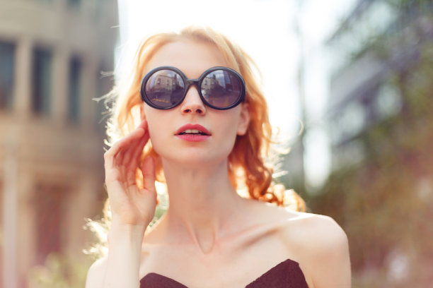姜女孩戴着墨镜在建筑物的背景，着色照片图片下载